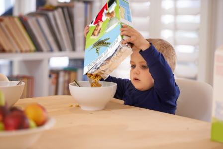 Un niño come cereales ultraprocesados