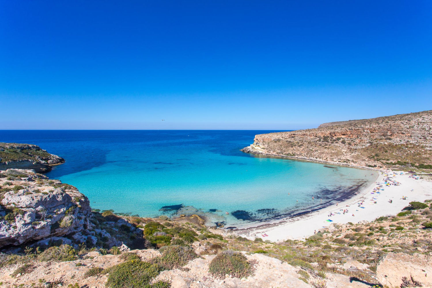 SPIAGGIA DEI CONIGLI, Lampedusa (Italia). Reserva virgen de belleza salvaje, es un arenal blanco de aguas cristalinas del sur de Sicilia. La playa ‘de los conejos’ es uno de los pocos rincones del Mediterráneo donde las tortugas bobas acuden a desovar