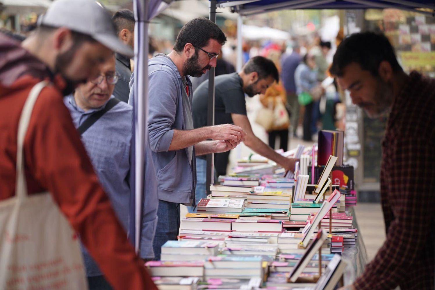 Compradores consultan libros en una parada de la Rambla de Barcelona