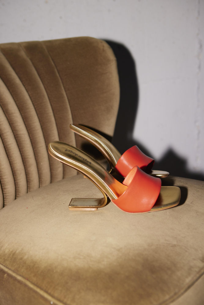 Jeffrey Campbell revolucionó el calzado en los años 2000 con sus atrevidos diseños retro bañados en colores llamativos. Sus vertiginosos tacones de plataforma se han moldeado con el tiempo y ahora presentan formas tan futuristas como el de la imagen. Bautizada como Geometric por su juego de líneas entre el empeine y el tacón, esta sandalia de piel naranja flúor y suela dorada aporta frescura a cualquier zapatero