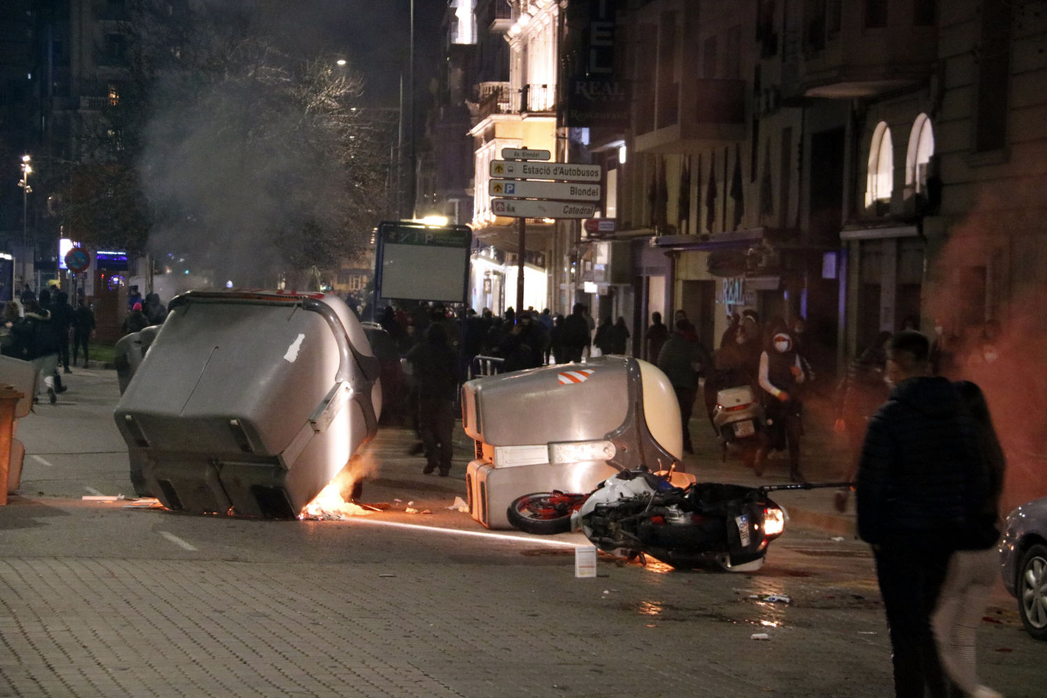 A protester throws a stone into flames during clashes with Catalan regional forces Mossos d'Esquadra after a demonstration against the arrest of Spanish rapper Pablo Hasel in Barcelona on February 16, 2021. - Spanish police stormed a university to arrest the rapper barricaded inside after being sentenced to nine months' jail over tweets attackiPeople participate in a protest in support of Catalan rap singer Pablo Hasel, after he was given a jail sentence on charges of glorifying terrorism and insulting royalty in his songs, in Barcelona, Spain, February 16, 2021. REUTERS/Nacho Doceng the monarchy and the police in a case denounced as an attack on freedom of speech. (Photo by Josep LAGO / AFP)