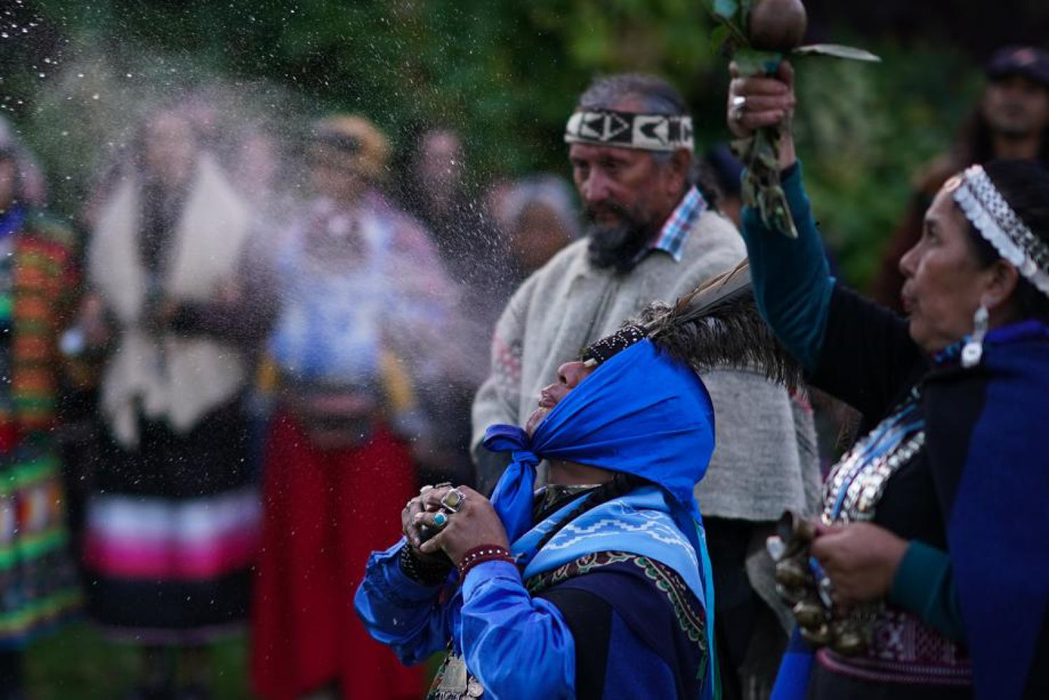 La Minga Indigena participa en una ceremonia del fuego sagrado en los jardines cercanos al Scottish Event Campus.