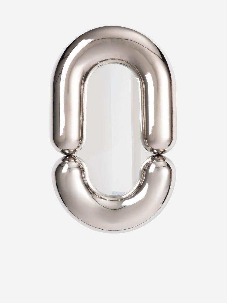 Espejo Zodiac, diseño de Jean-Baptiste Fastrez para Moustache. De  cerámica acabada en tono platino brillante, semeja inflado aunque es rígido. Mide 110 cm de alto
