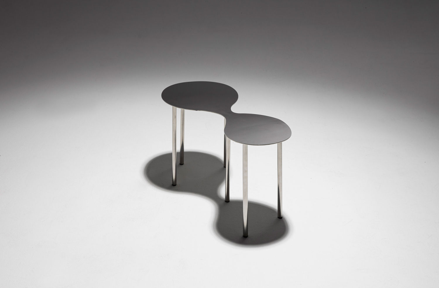 Colección Mesitas Archipielago de Brats Estudio, en galería Il·laciones. Bruñidas planchas de acero inoxidable con formas orgánicas y  función extra de espejo