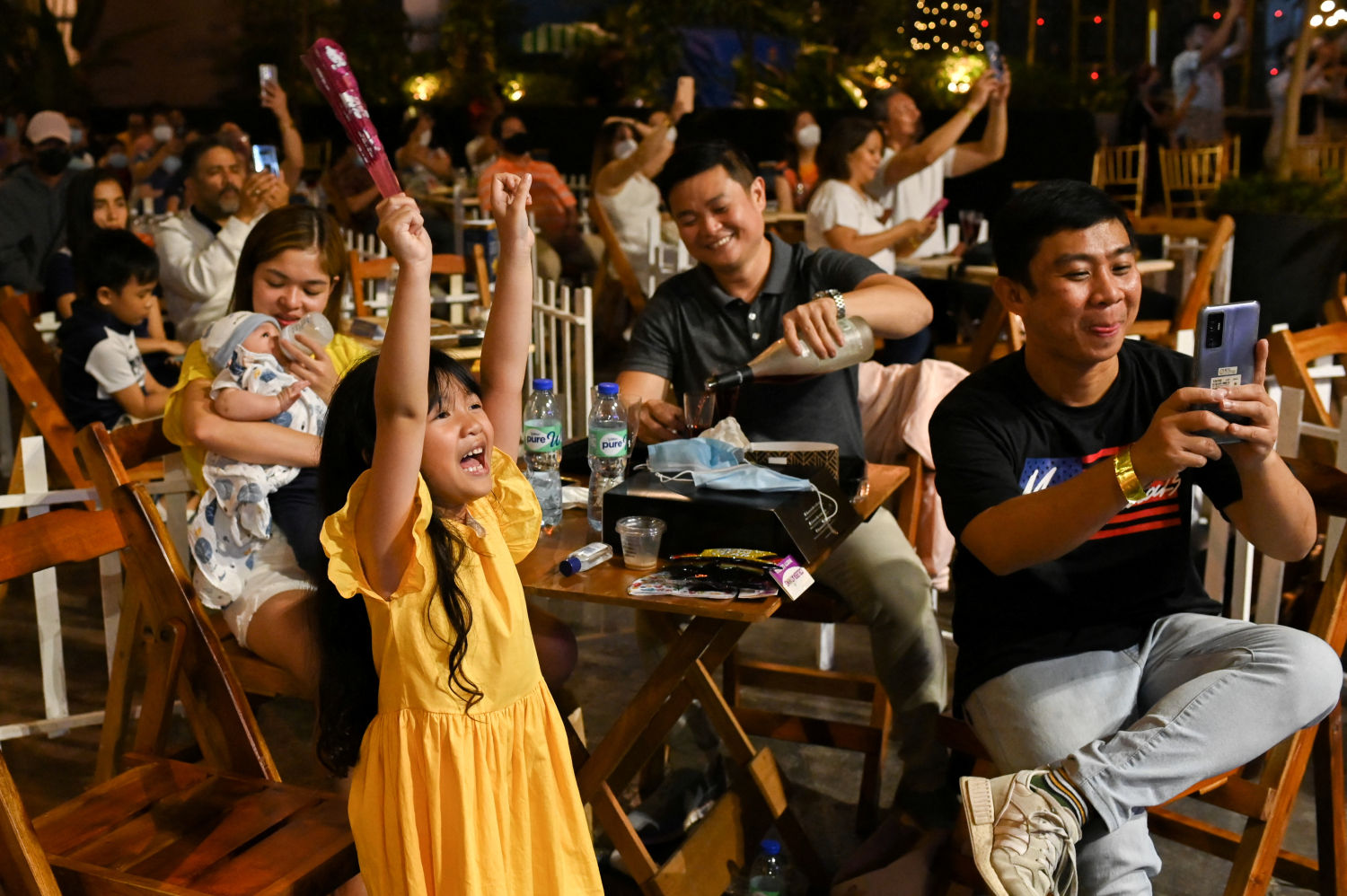 Varias personas reunidas  mientras esperan la llegada del Año Nuevo en Eastwood Mall, en Quezon City, Filipinas