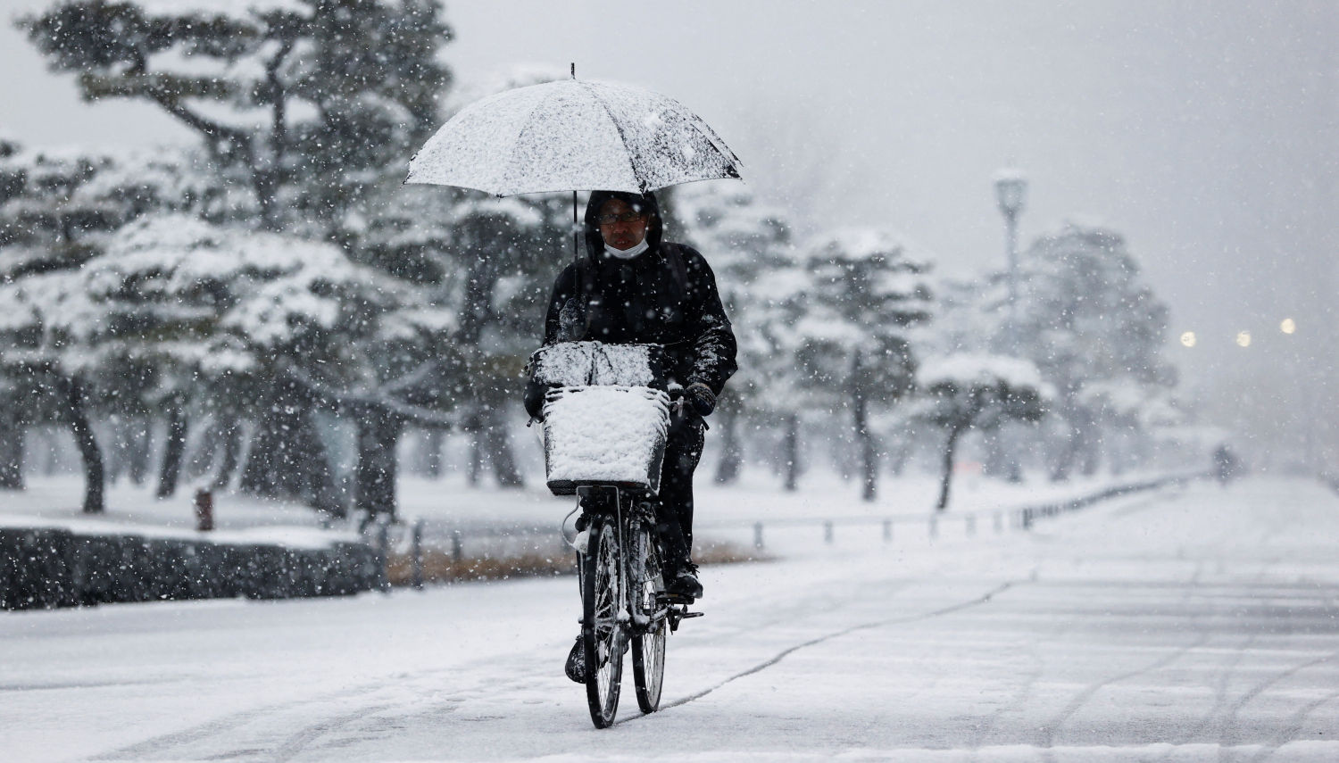 Un hombre en su bicicleta en la nevada de Tokio, en Japón.