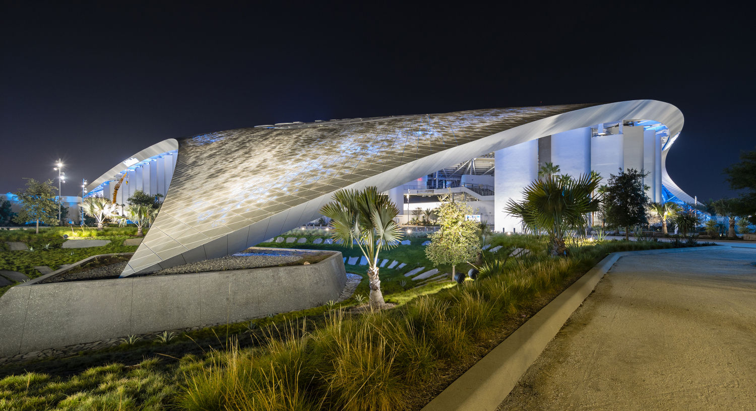 SoFi Stadium (Premio Versailles) en Inglewood, Estados Unidos. El estadio es parte del paisaje y el paisaje es parte del estadio. Su cubierta hecha de ETFE (un tipo de plástico) translúcido que por un lado permite ver el cielo, y por otro también puede hacer de pantalla gigante que proyecta imágenes en movimiento por su parte exterior