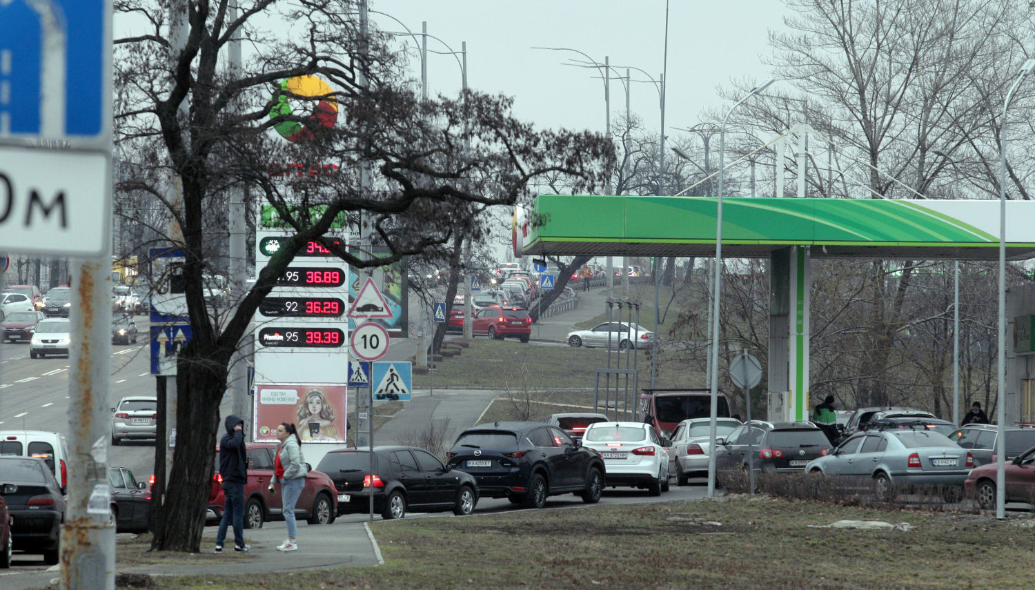 Los coches se alinean frente a una gasolinera para llenar sus depósitos en la capital Kiev tras la invasión rusa de Ucrania.