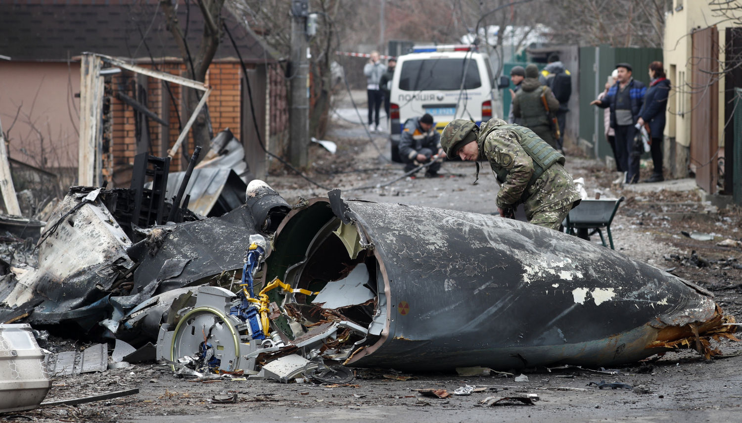 Un soldado observa los restos de un avión militar derribado durante la noche del 25 de febrero de 2022 en Kiev, Ucrania.