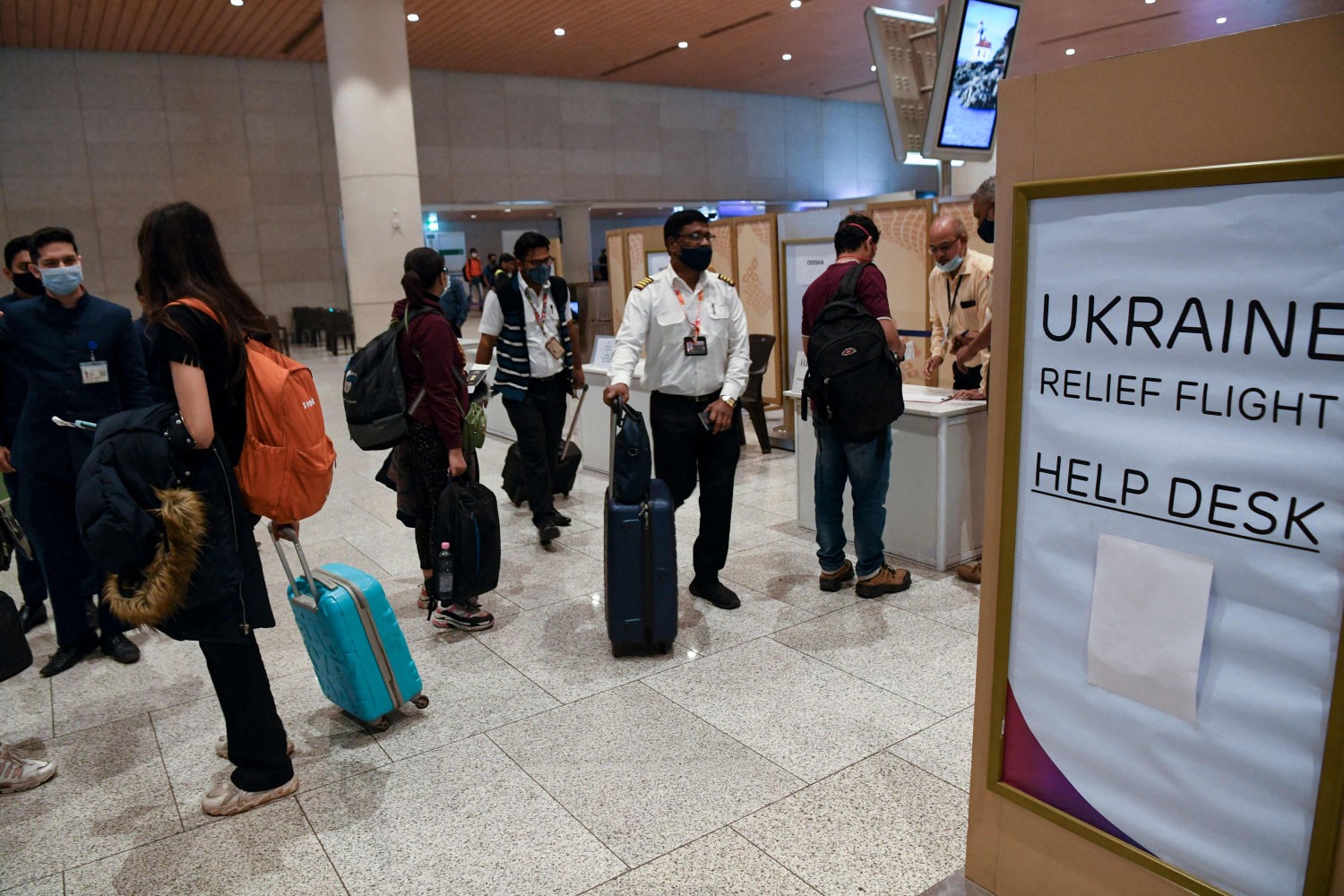 Los estudiantes evacuados de Ucrania en un vuelo especial desde Bucarest esperan las instrucciones de los funcionarios al llegar al Aeropuerto Internacional Chhatrapati Shivaji Maharaj en Mumbai.