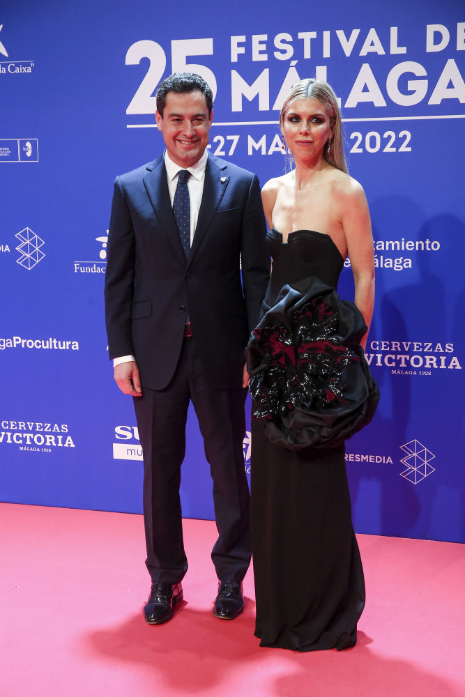 Juanma Moreno, presidente de la Junta de Andalucía, con su mujer Manuea Villena vestida con un traje negro de Roberto Diz.