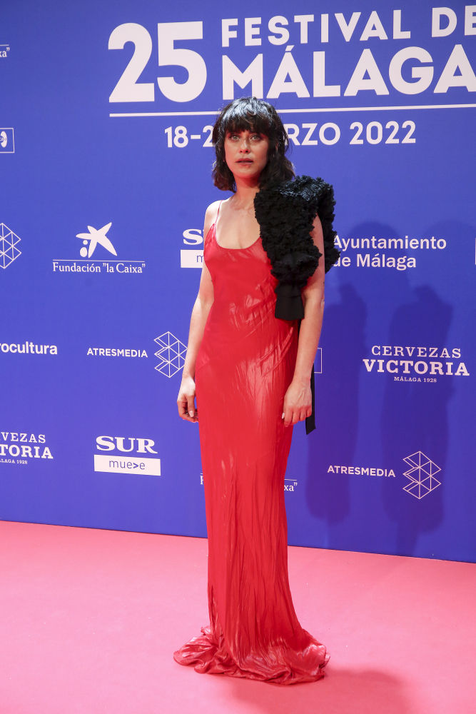 María León con un vestido lencero de tejido satinado en relieve color rojo de  Philosophy di Lorenzo Serafini con una estola de borreguito negra
