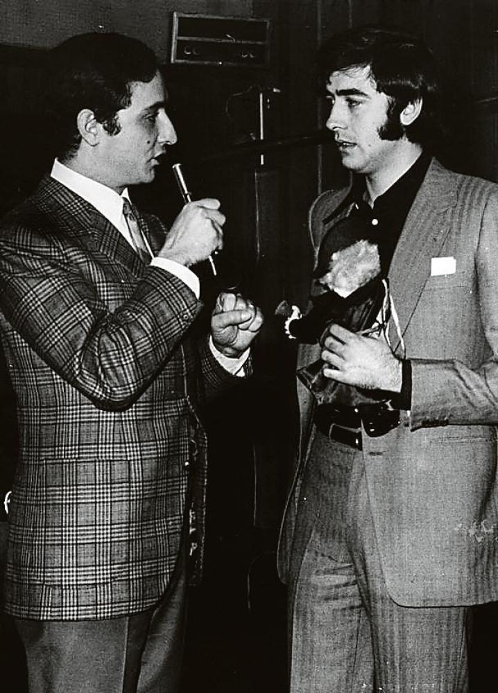 EL POPULAR CANTANTE JOAN MANUEL SERRAT EL DÍA QUE CUMPLÍA 25 AÑOS. CON DICHO MOTIVO, EL CLUB JUVENIL DE RADIO BARCELONA, QUE PRESENTA EL LOCUTOR SALVADOR ESCAMILLA, LE RINDE UN CÁLIDO HOMENAJE OBSEQUIÁNDOLE CON UN MUÑECO MASCOTA.