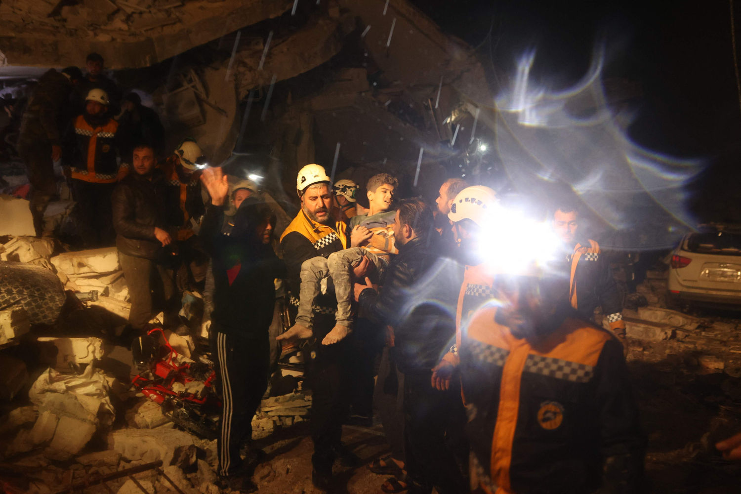 Los equipos de rescate llevan a un niño que sacaron de los escombros de un edificio derruido tras el terremoto en Dana, Idlib controlada por los rebeldes, Siria