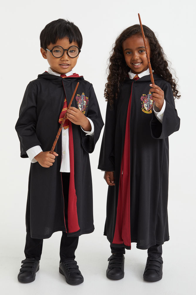 Harry Potter x H&M. Disfraz de tres piezas que te transportará de manera instantánea al mundo de Harry Potter como un alumno más de la prestigiosa escuela de Hogwarts. Capa de punto con capucha puntiaguda, mangas largas trompeta y cierre autoadherente en el cuello. Corbata anudada en los colores de Gryffindor con tira elástica ajustable y cierre de plástico detrás. Varita mágica de plástico. Largo 34 cm. Conjunto de disfraz de 3 piezas 24,99 € de H&M.