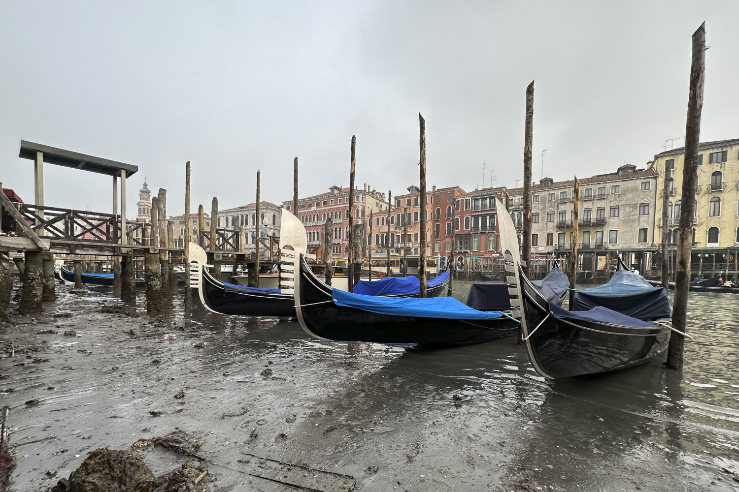 Unas góndolas aparcadas a lo largo de un canal durante la marea baja en Venecia, Italia, el sábado