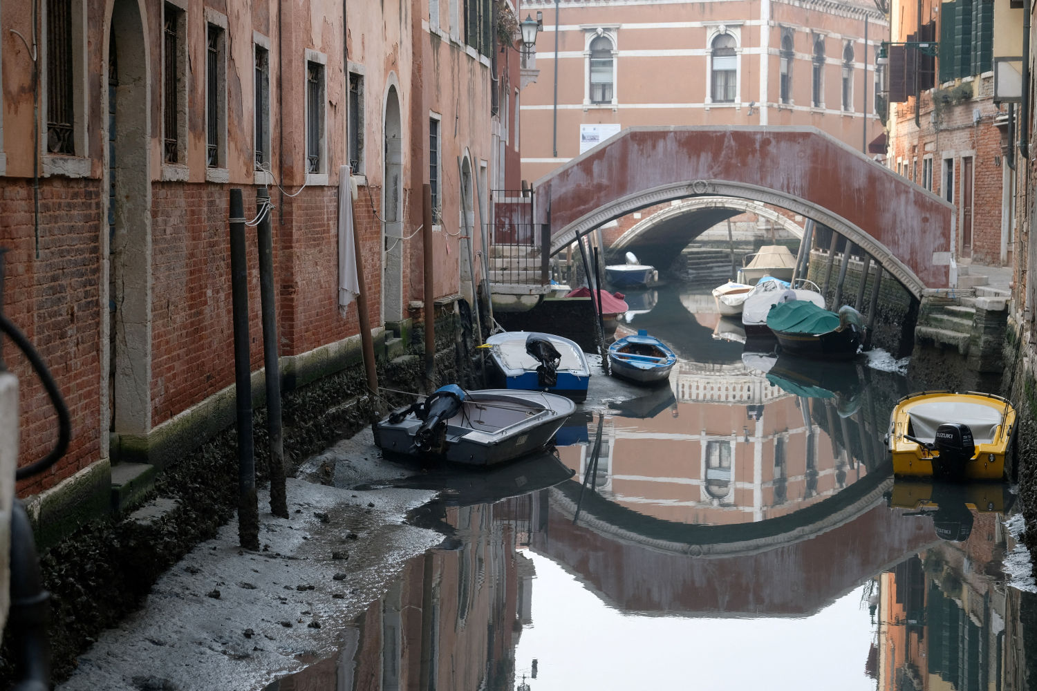 Los barcos se muestran en un canal durante una marea baja severa en la ciudad laguna de Venecia, Italia
