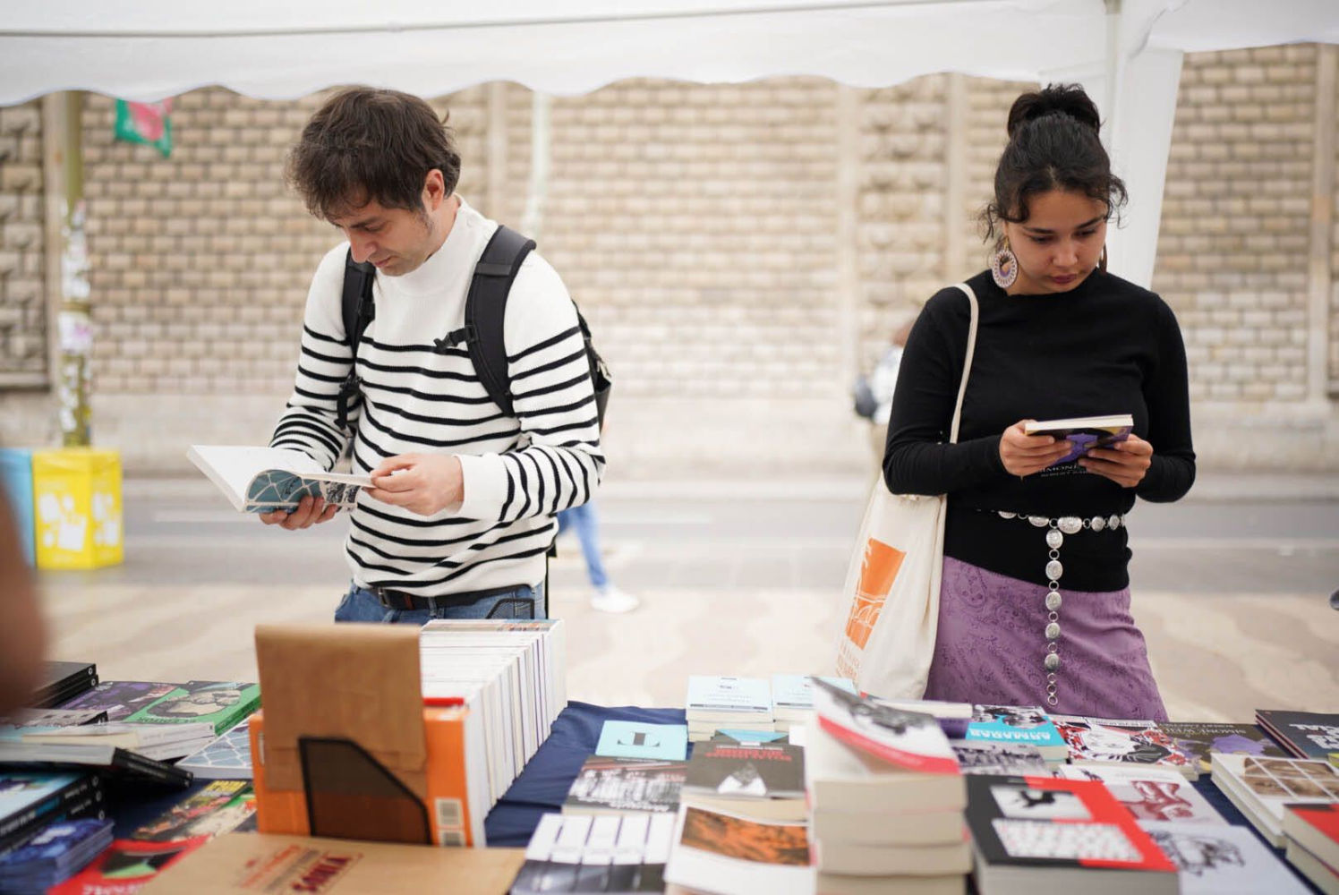 Dos personas consultan libros en una parada de Sant Jordi