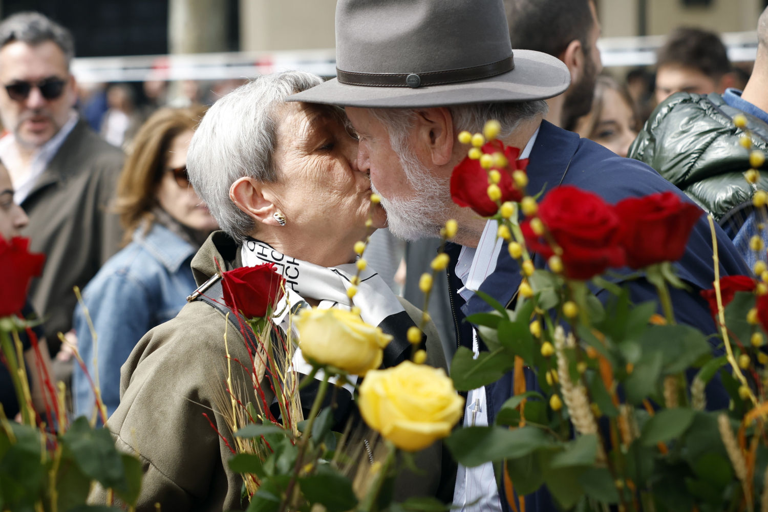 Una pareja se besa después de comprar una rosa en la 