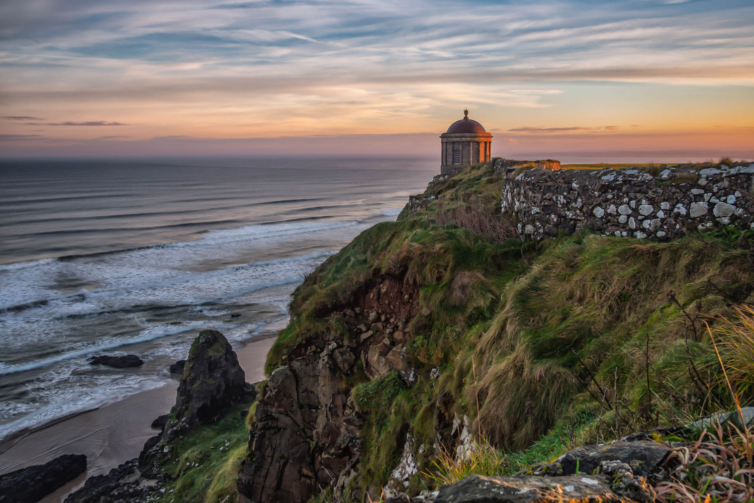 DOWNHILL (Londonderry, Irlanda del Norte). Vecina de Benone, desde lo alto de los acantilados, sus amaneceres con la cúpula del templo Mussenden de fondo son espectaculares. Los fans de ‘Juego de Tronos’ reconocerán esta playa de arena blanca como escenario de Rocadragón