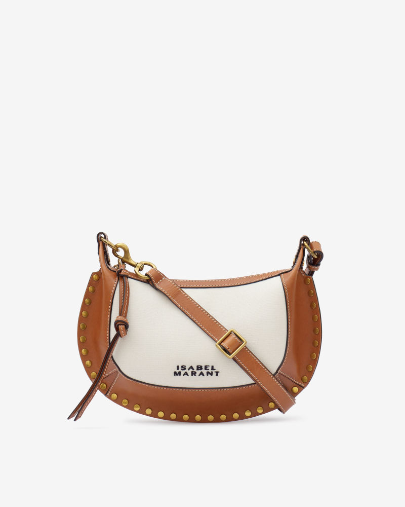 El icónico bolso de hombro tipo baguette de Isabel Marant se versiona en piel bovina y algodón y se adorna con tachuelas doradas con aires de western