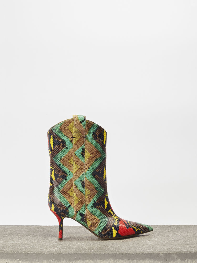 Los flecos y los prints invaden la colección de invierno de The Saddler. Uno de sus modelos más populares es el botín Carmen, con tacón fino y una colorida piel de pitón estampada