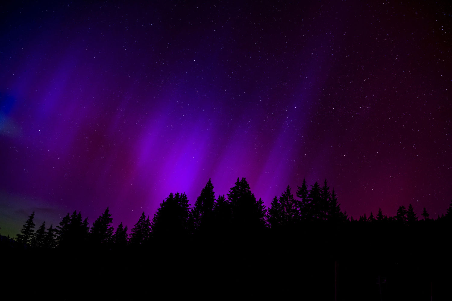 La aurora boreal ilumina el cielo nocturno de las montañas en el paso le Col des Mosses, Suiza.
