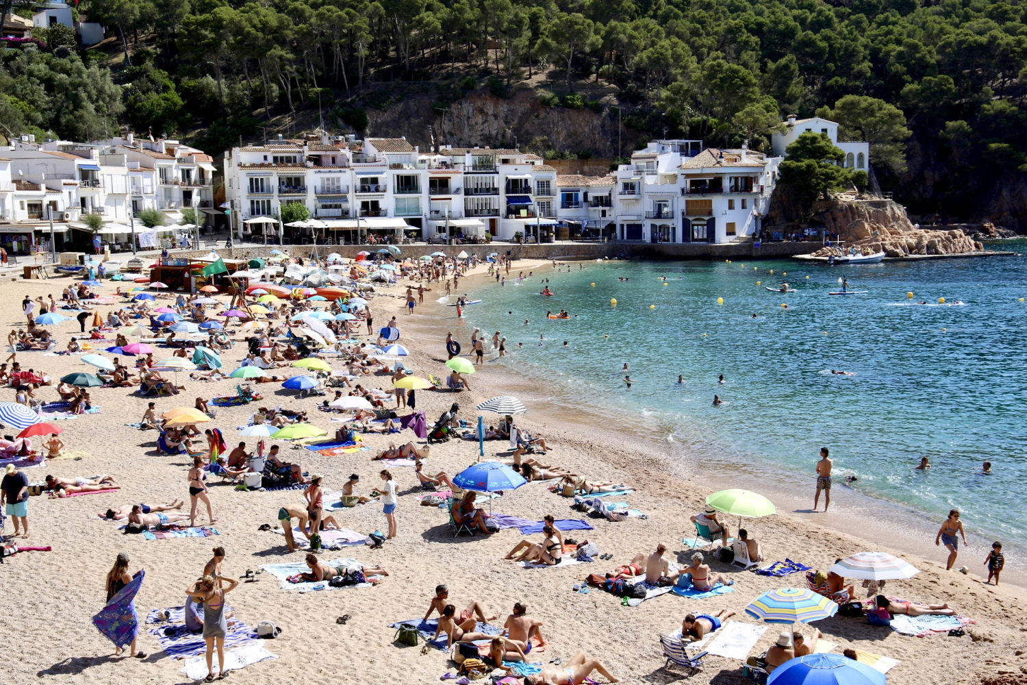 Vista de la playa de Tamariu llena de bañistas.