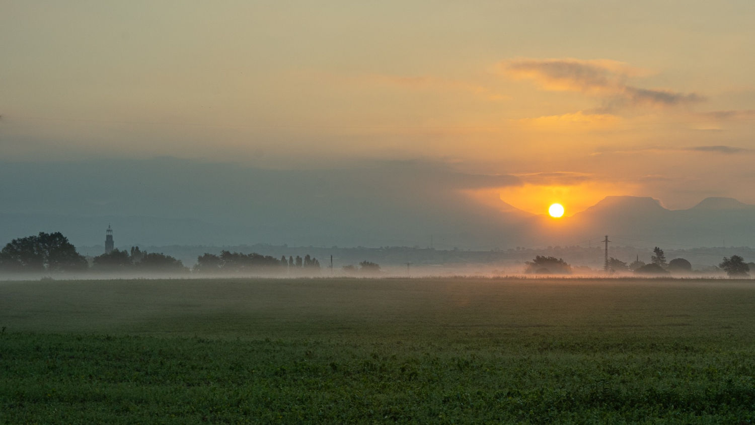Niebla baja en el campo de cereales tras la siega en Manlleu.