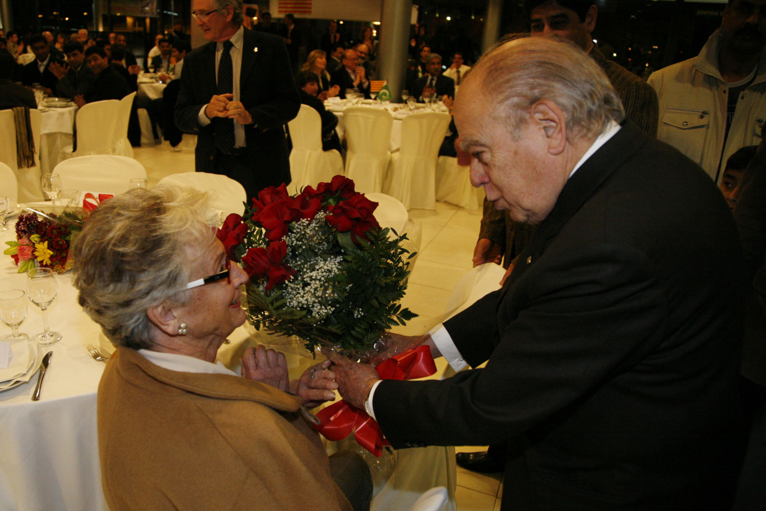 Jordi Pujol entrega un ramo de flores a su mujer durante un acto institucional.