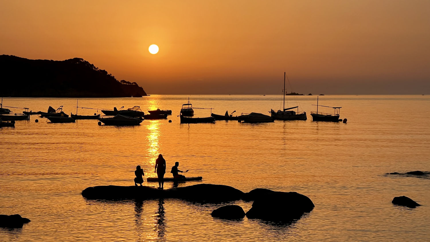 Contemplando el amanecer sobre una roca en la Fosca.