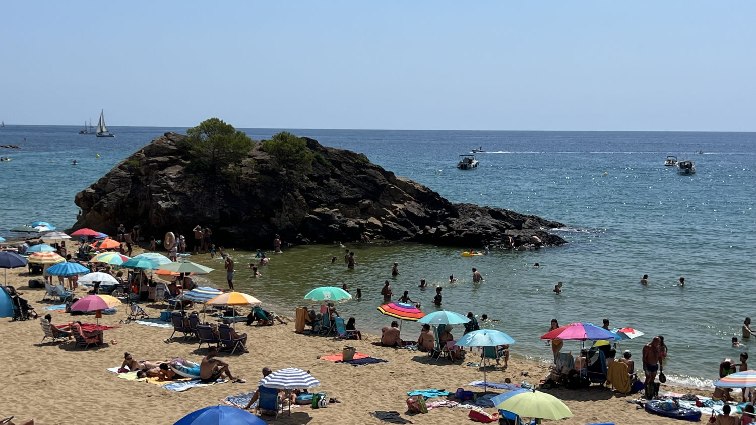 Parasoles en torno a la roca de la Fosca.