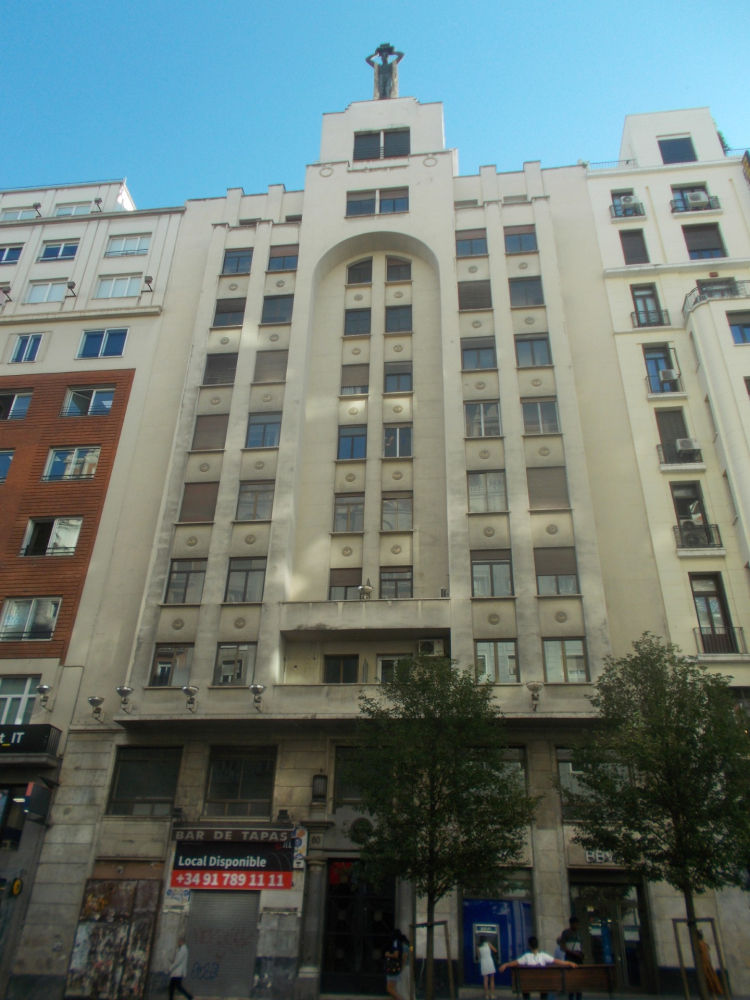 Escultura 'El Romano' en lo alto del edificio, en la Gran Vía de Madrid.