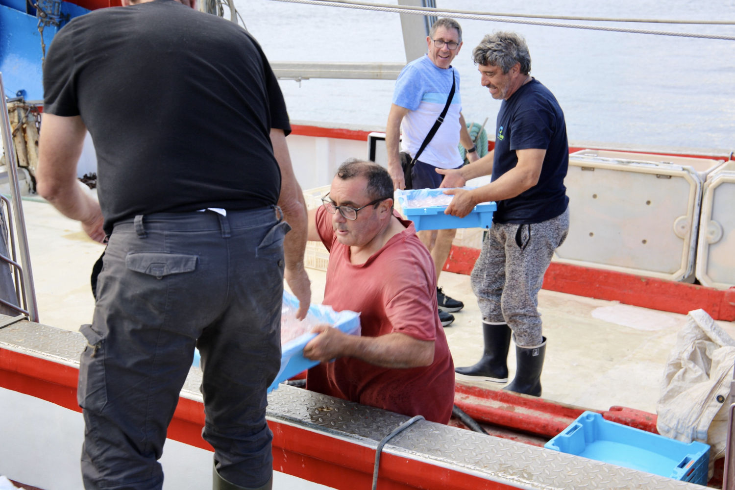 Los pescadores descargando las gambas del barco.