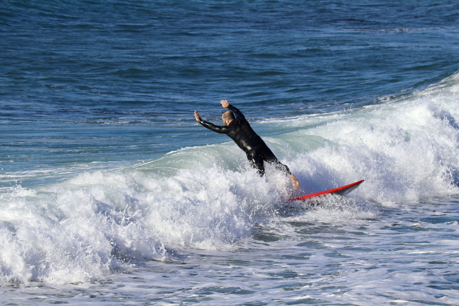Rompiendo la ola en la playa de Sant Feliu de Guíxols.