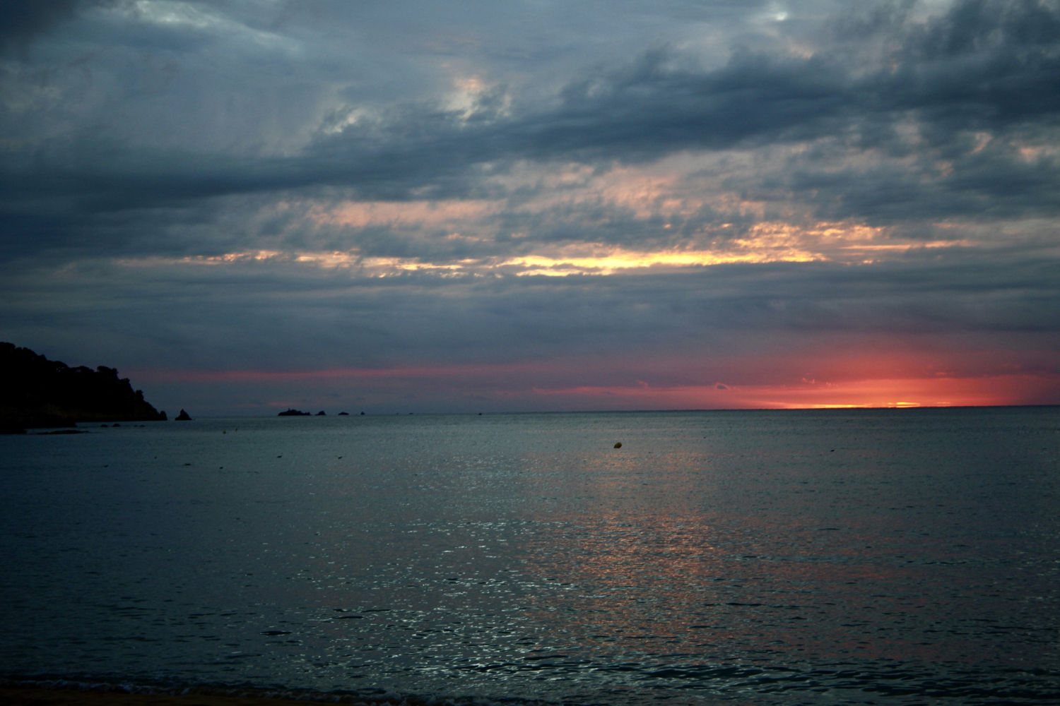 El sol intenta salir entre las nubes en La Fosca de Palamós.