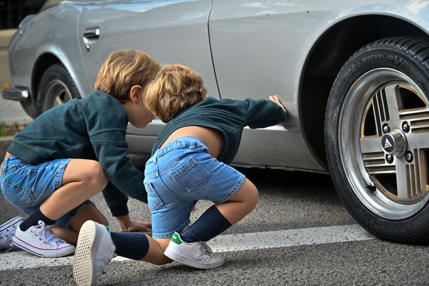 Niños curioseando un coche clásico.