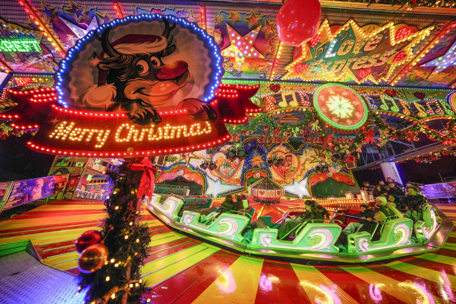 La gente disfruta de un paseo en un parque de atracciones navideño en Herne, Alemania, el viernes por la noche, 6 de diciembre de 2024.