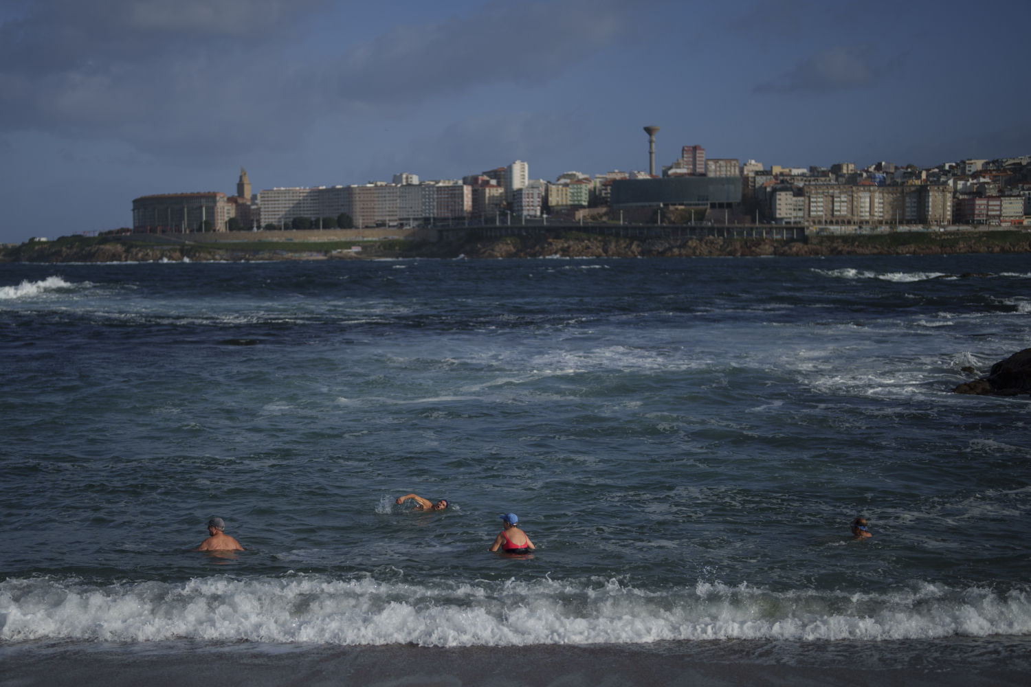 Un grupo de personas nada en el océano Atlántico en la playa de Riazor, en La Coruña, en el noroeste de España, el sábado 7 de diciembre de 2024