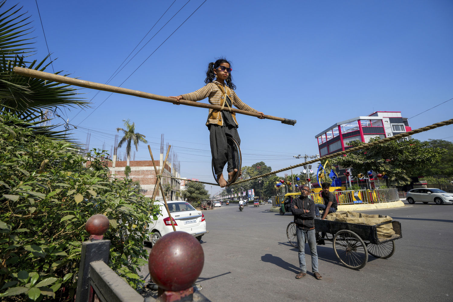 María, de seis años, muestra sus habilidades para caminar sobre la cuerda floja a cambio de limosna en una carretera en Prayagraj, India, el 5 de diciembre de 2024.