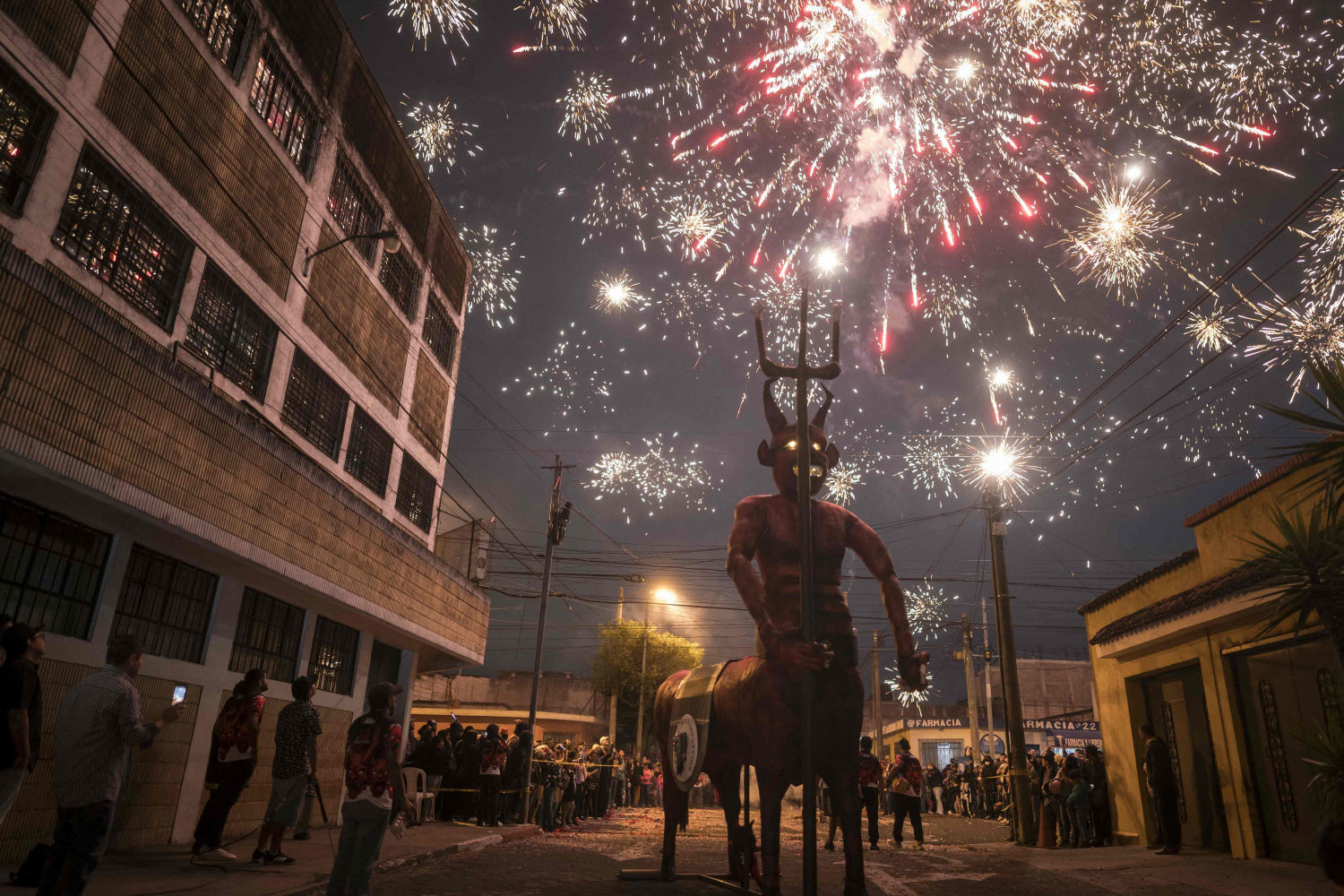 Fuegos artificiales explotan sobre la figura de un diablo antes de ser incendiados como parte de las celebraciones en honor a la Virgen de la Inmaculada Concepción en la Ciudad de Guatemala.