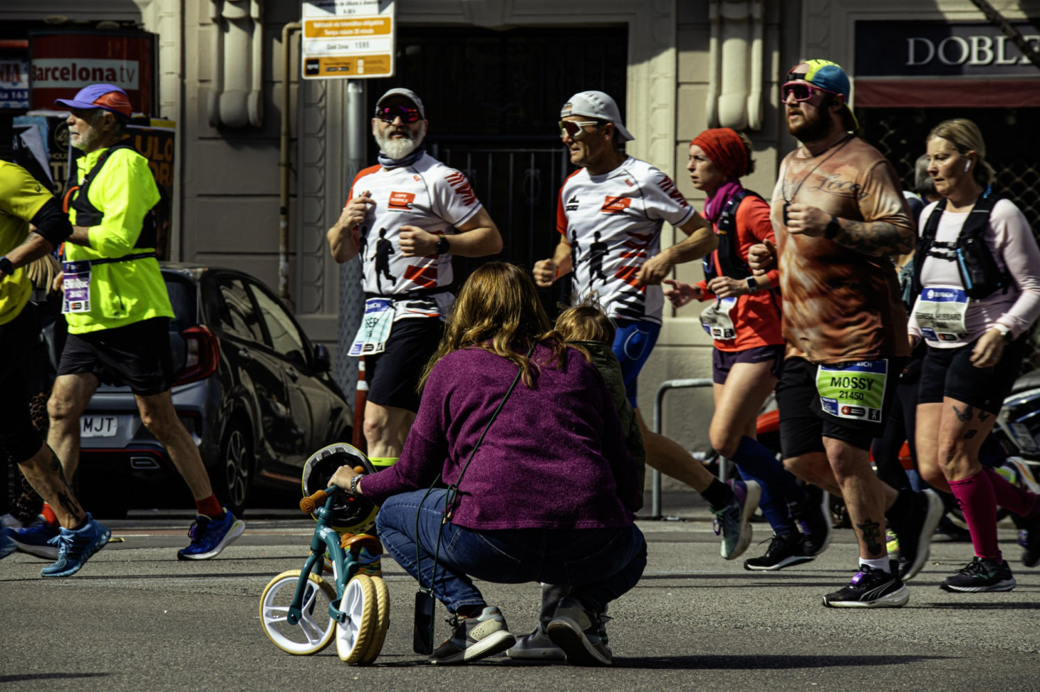 Una madre con su hijo, al paso de los corredores.