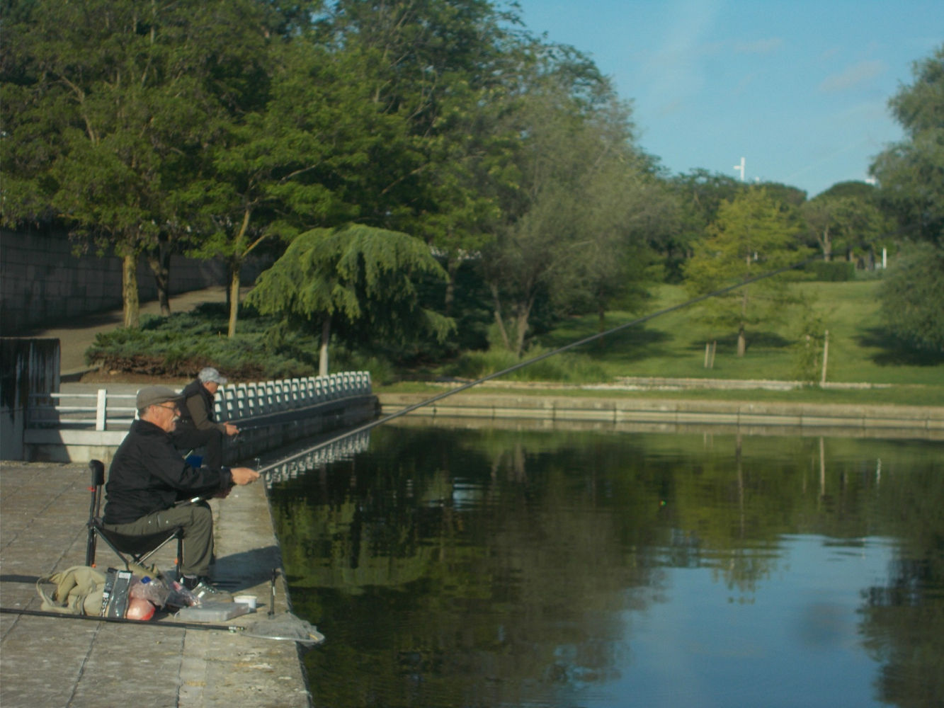 Pescadores con sus cañas probando suerte en el lago del parque Juan Carlos I.