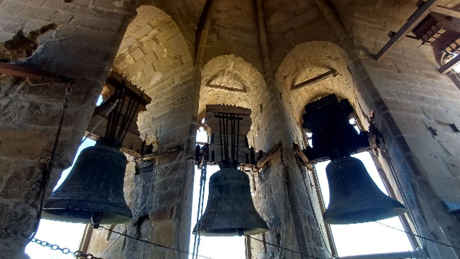 Las campanas se encuentran en ventanas con forma de arco y molduras decorativas.