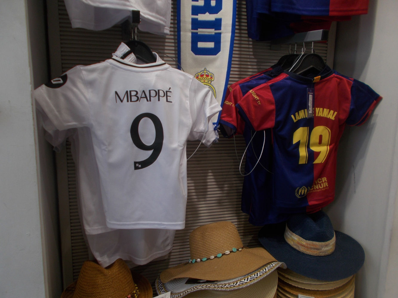 Camisetas del Madrid y del Barça, en una tienda madrileña.
