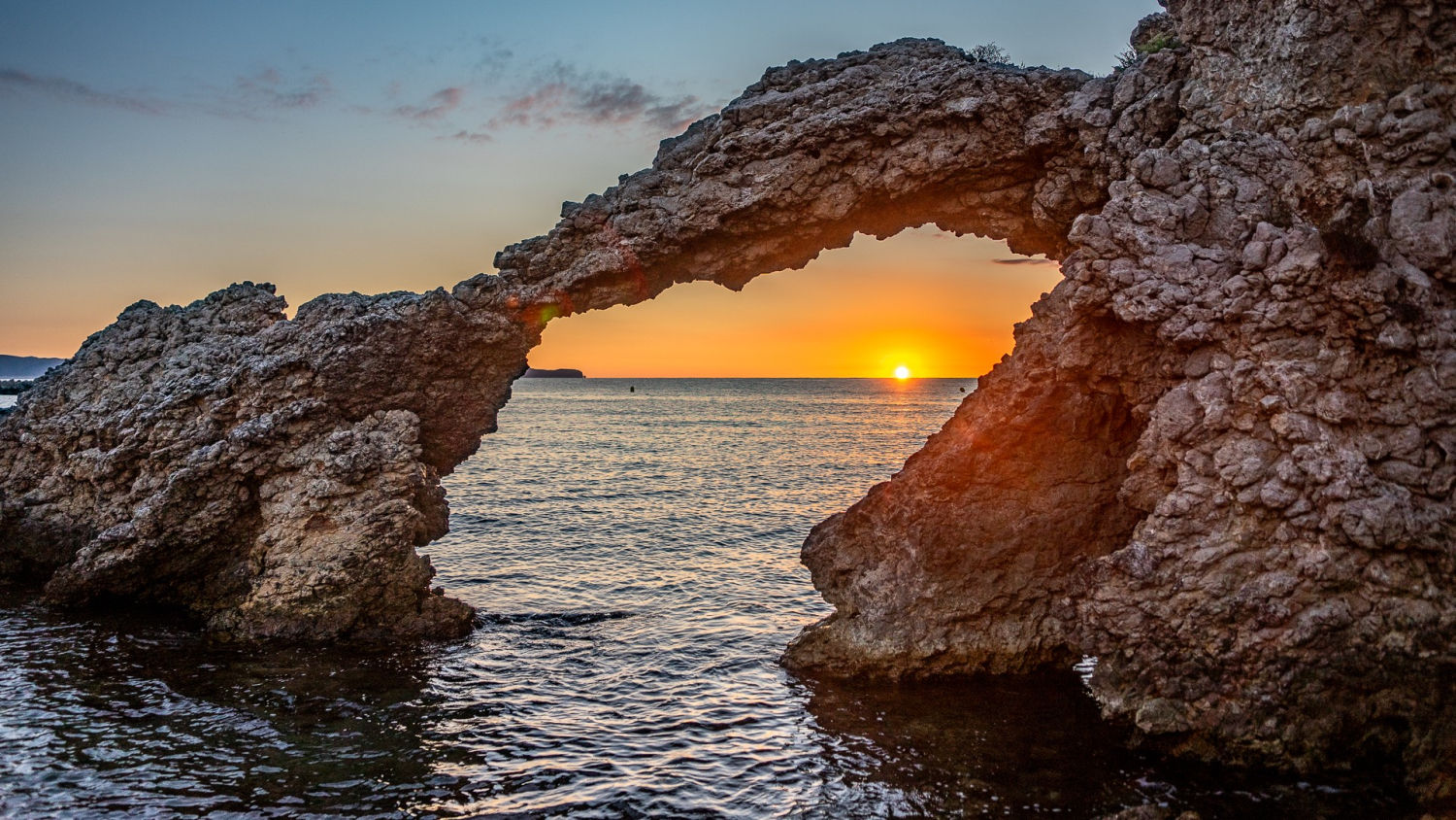 El sol encajado en el arco de El Portitxol.