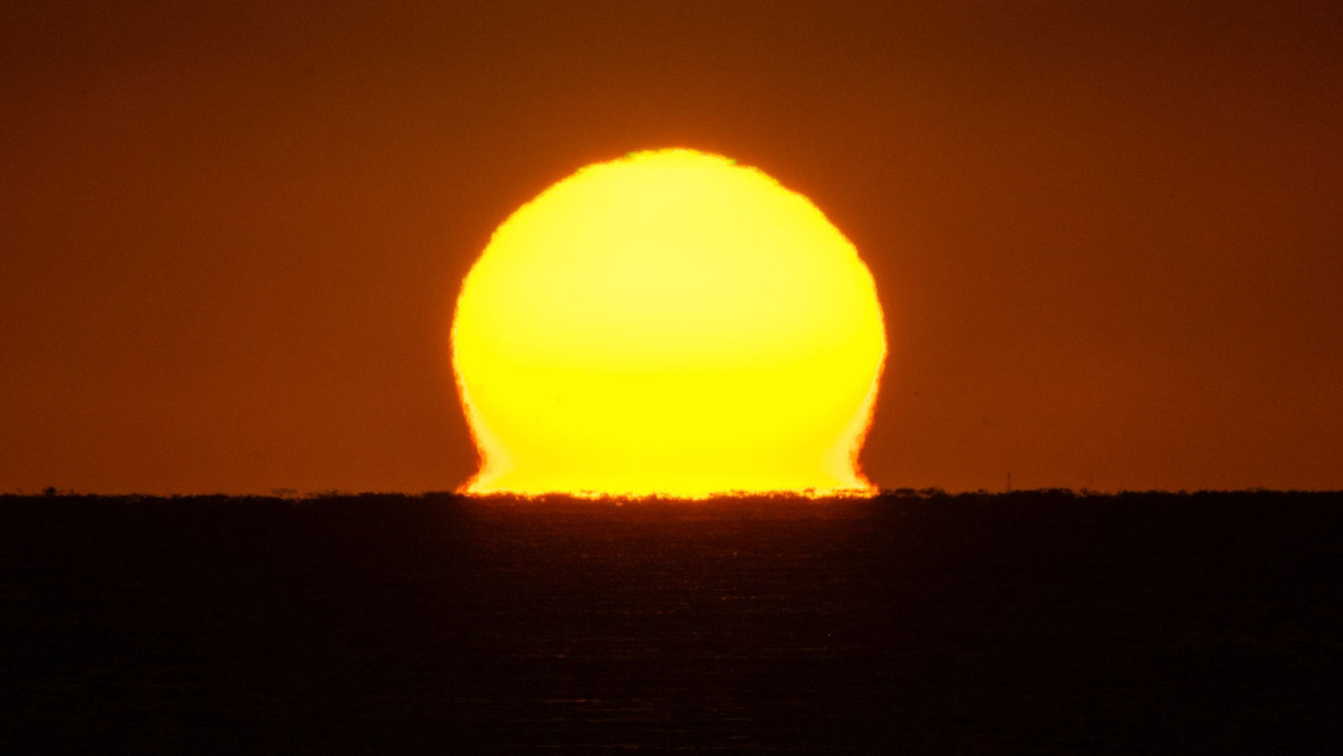 El sol deformado del amanecer en El Portitxol.