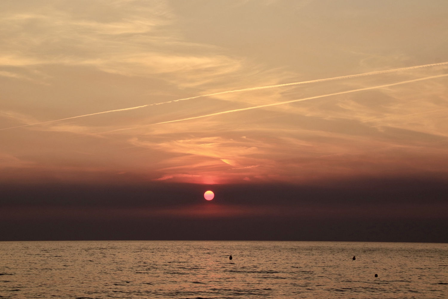 Estelas de condensación en el amanecer de Begur.