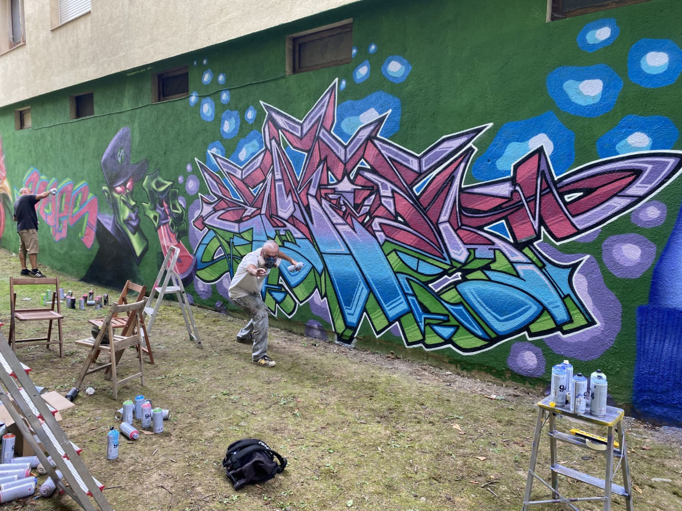 Artistas urbanos en pleno trabajo creativo.