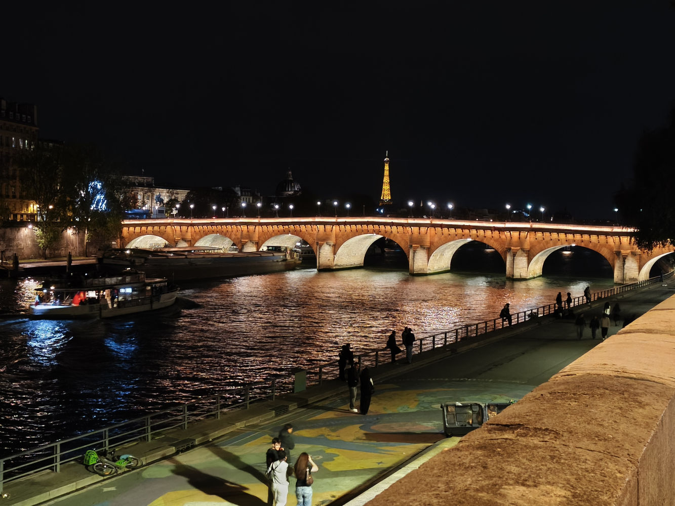 El río Sena, de noche, con la Torre Eiffel al fondo.